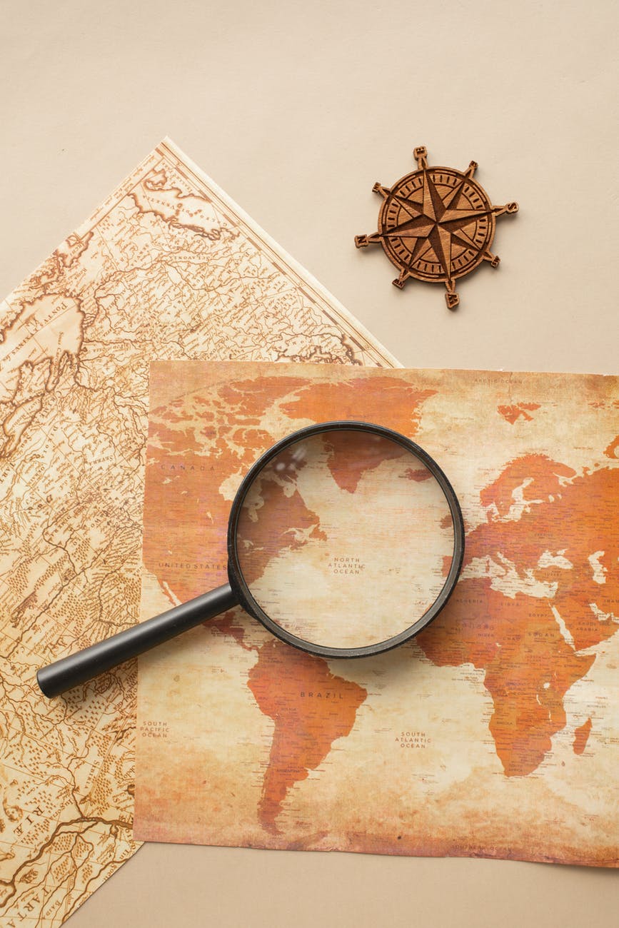 magnifying glass and wind rose on maps